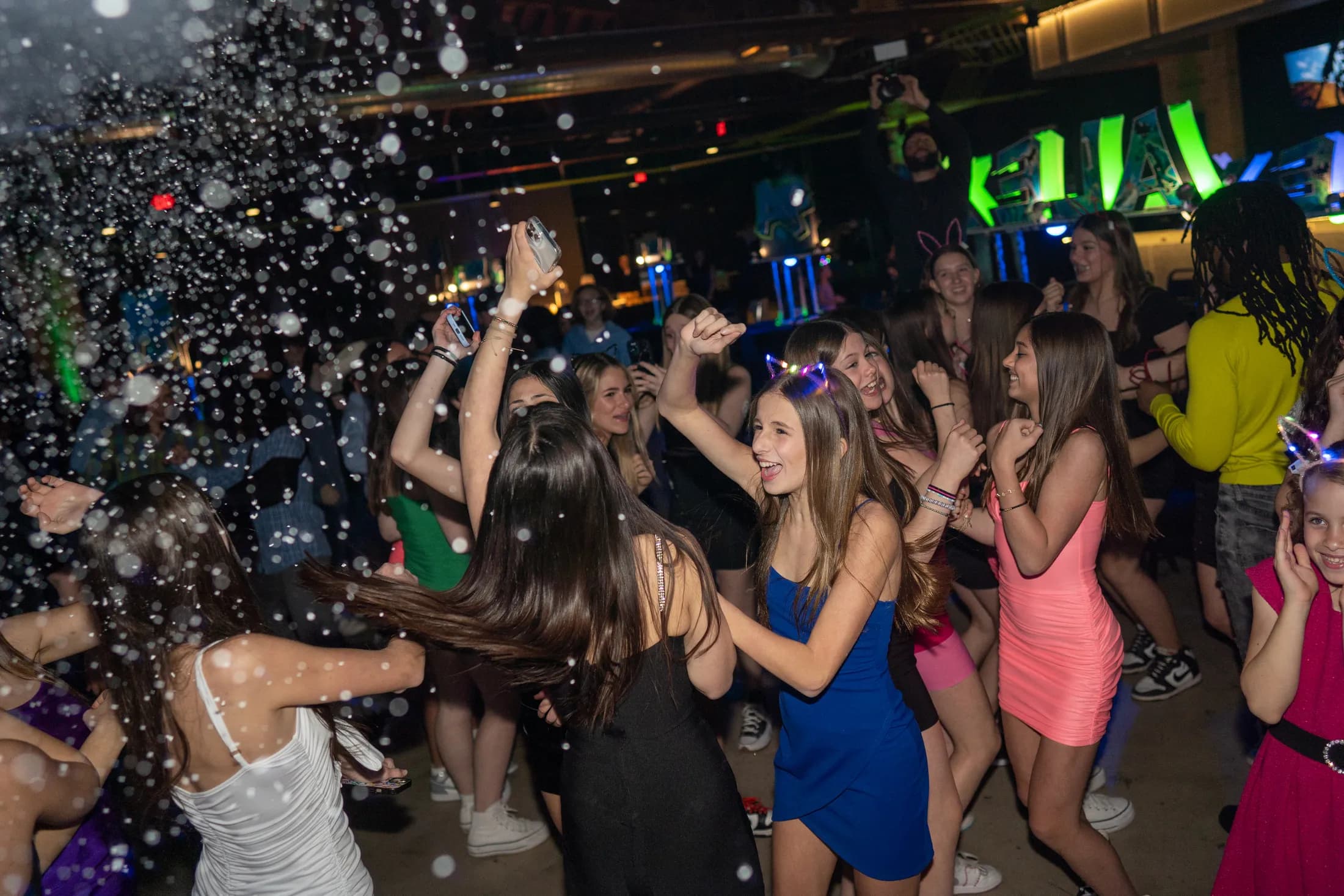 Guests dancing under a foam cannon at a mitzvah celebration at Ignite Arcade.