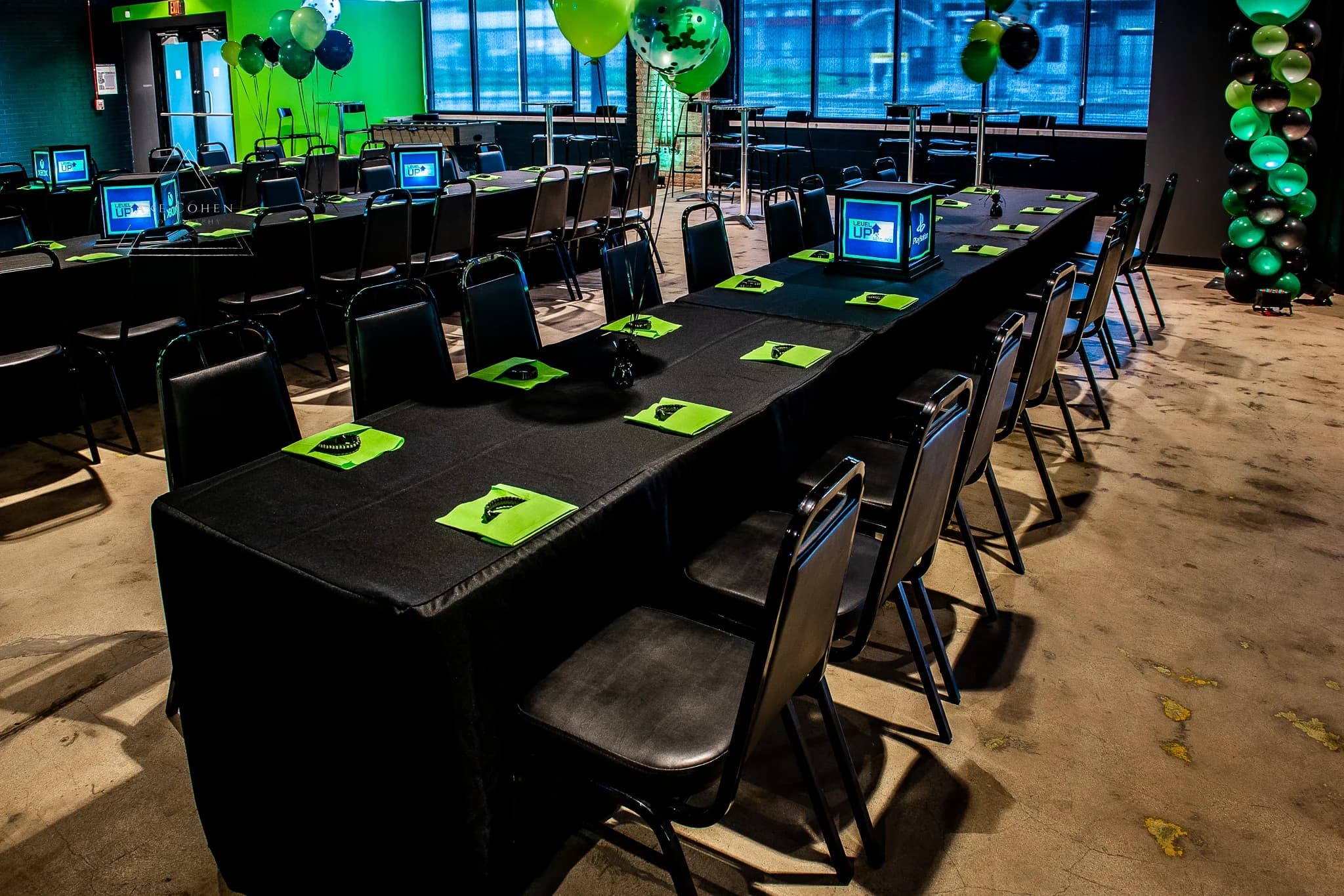 Long party table set with place settings and console screens at Ignite Arcade.