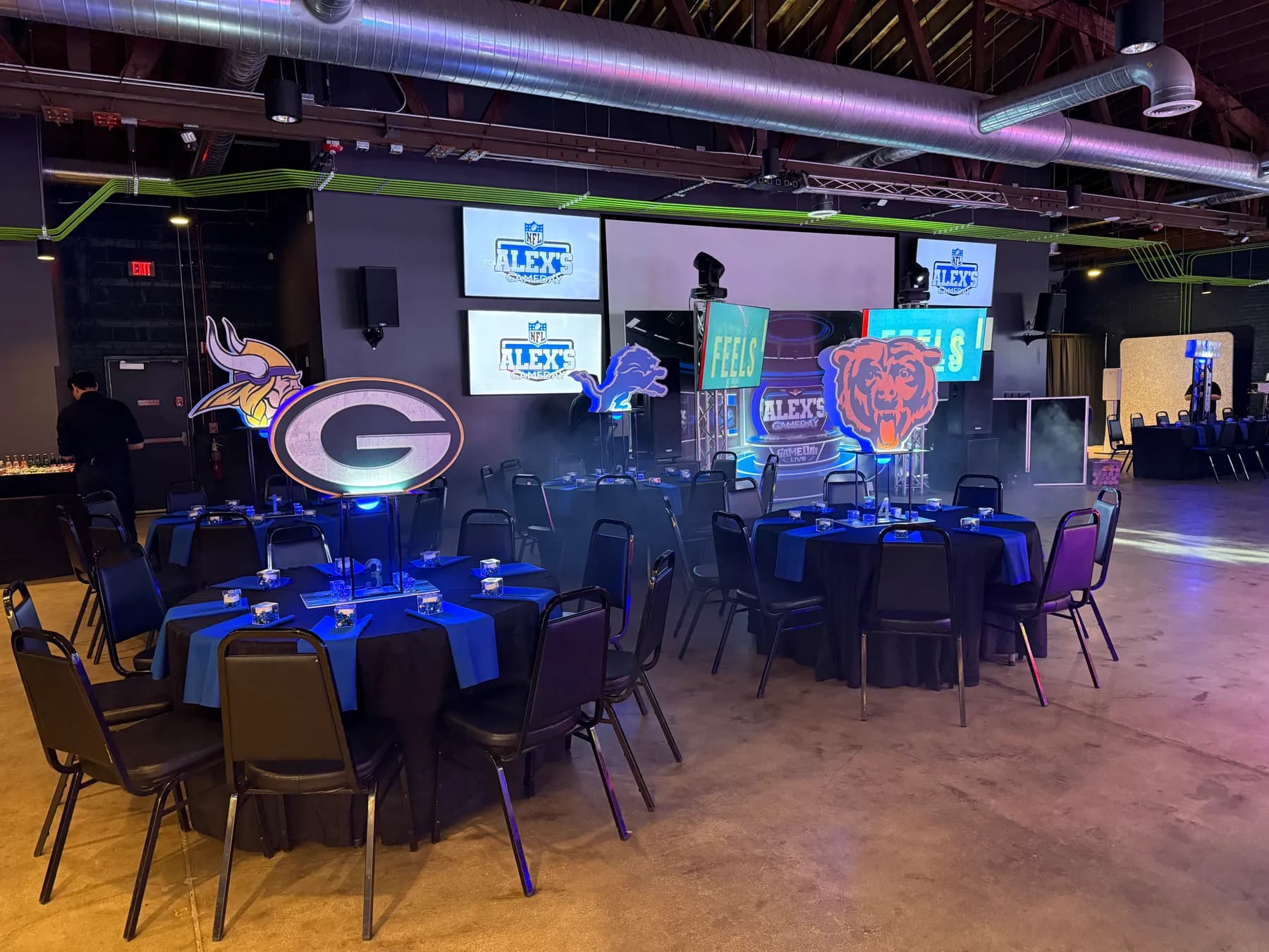 A mitzvah laid out with round dining tables and themed centerpieces at Ignite Arcade.