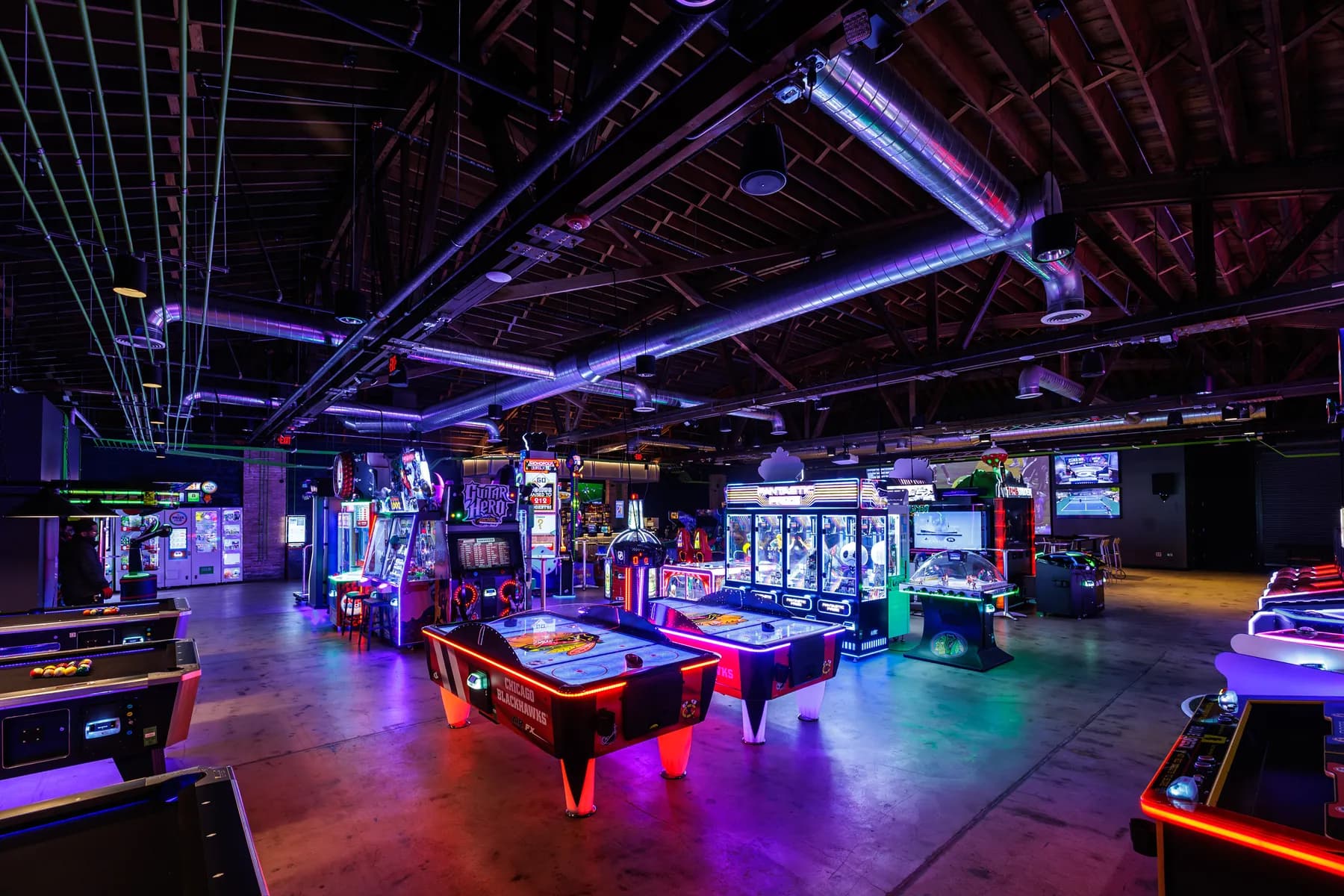 Ignite Arcade's neon-lit arcade floor packed with games.
