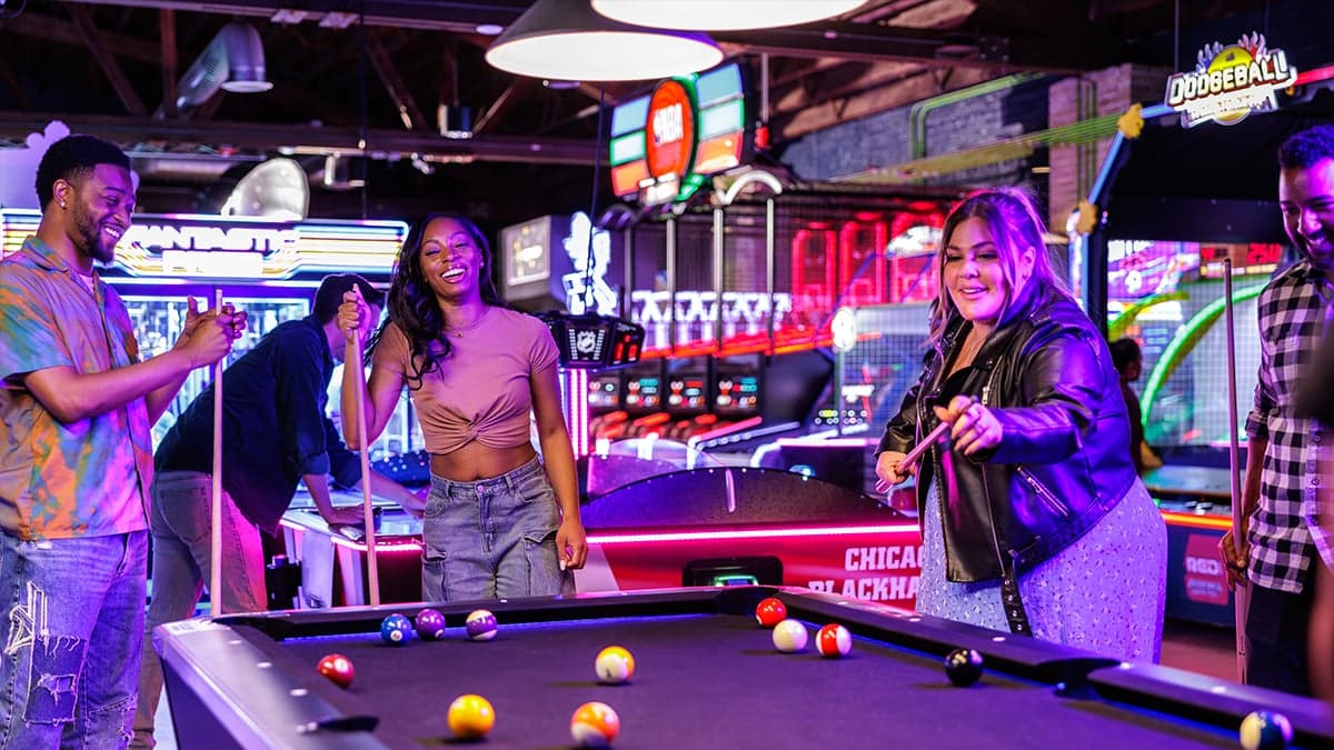 Pool tables under neon lighting at Ignite Arcade.