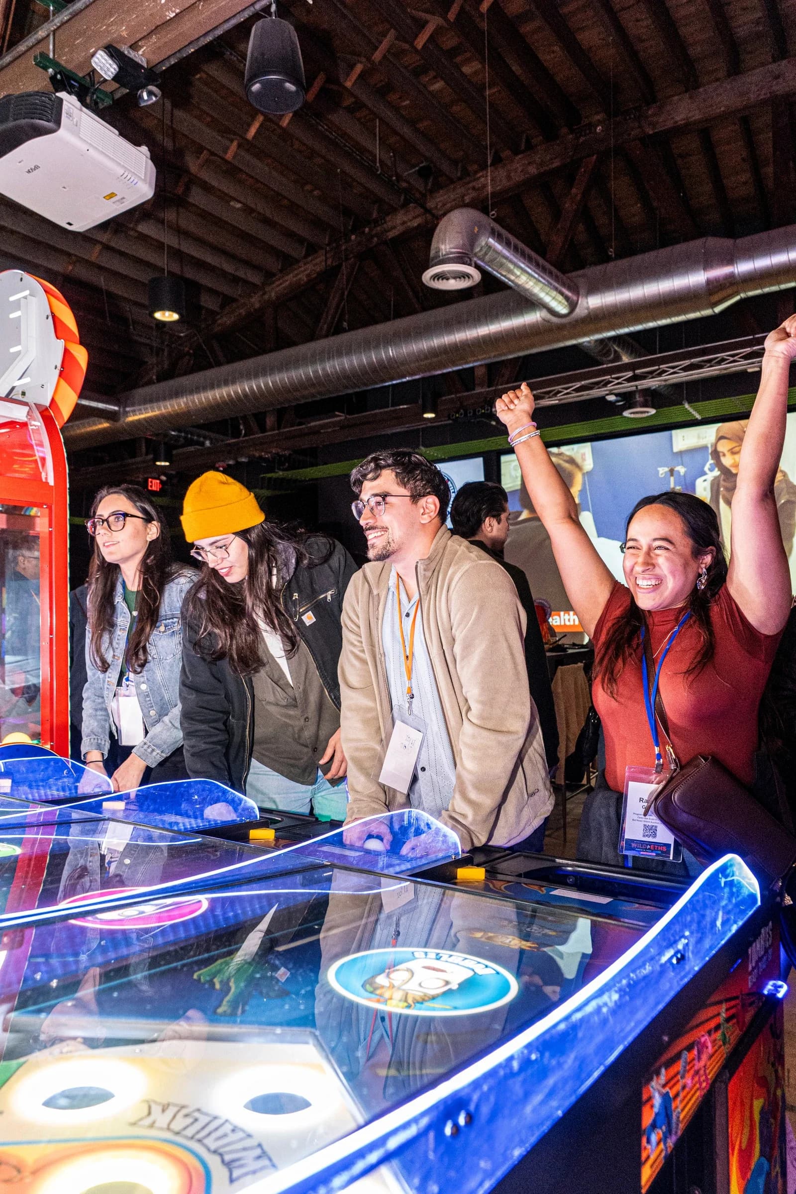 A group cheering at an air hockey table during a private event at Ignite Arcade.